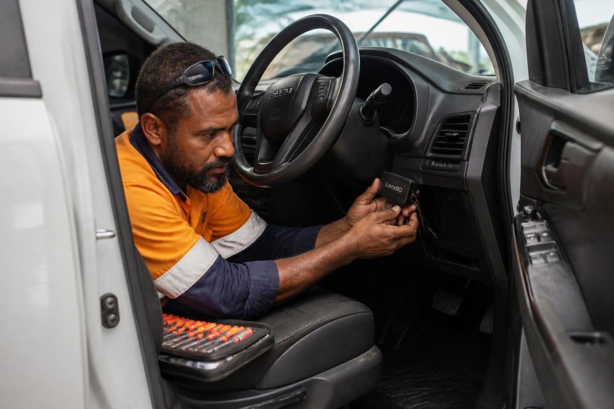 Technician installing a GPS tracker in a vehicle